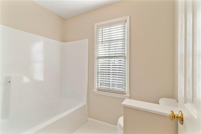 full bath with tile patterned floors, toilet,  shower combination, and baseboards