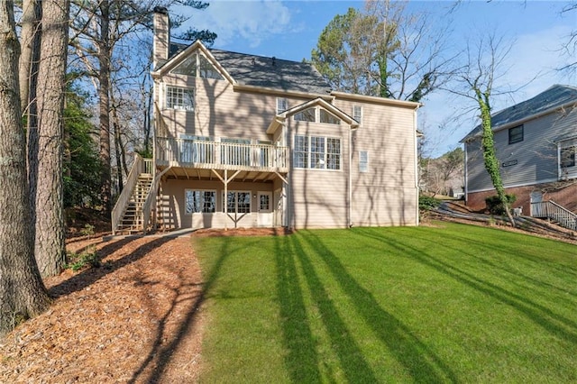 back of property with a wooden deck, stairway, a chimney, and a yard