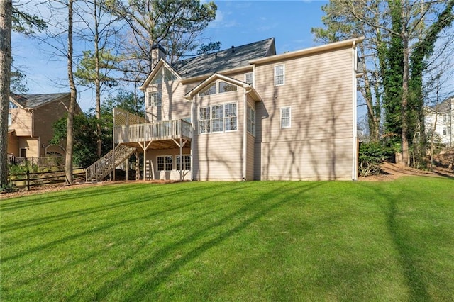 rear view of house featuring fence, stairs, a chimney, a deck, and a yard