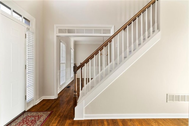 foyer entrance with stairs, wood finished floors, visible vents, and baseboards