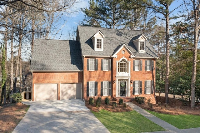 view of front of house featuring brick siding, driveway, and a shingled roof