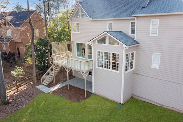 rear view of property with a wooden deck, a yard, and stairs