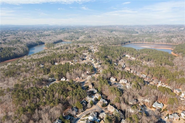 drone / aerial view featuring a water view and a wooded view