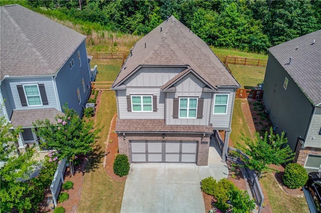 6410 Crosscreek Ln, Flowery Branch, GA 30542 - view of front facade with board and batten siding, brick siding, an attached garage, a shingled roof, and driveway