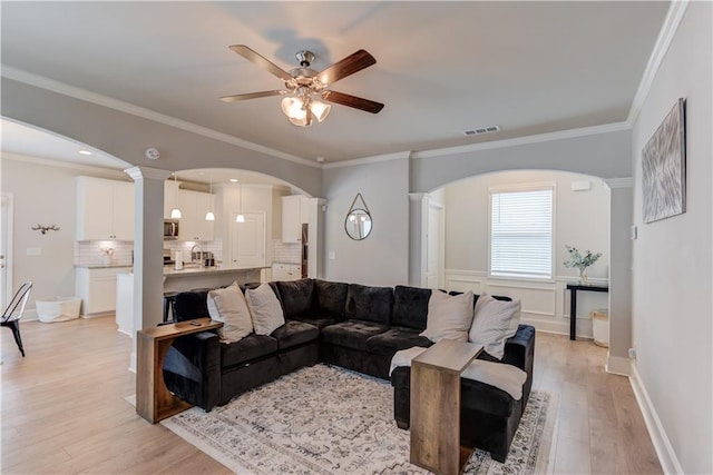6410 Crosscreek Ln, Flowery Branch, GA 30542 - living room with ceiling fan, light wood finished floors, arched walkways, and ornamental molding