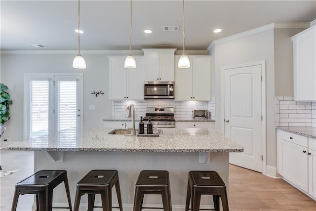 6410 Crosscreek Ln, Flowery Branch, GA 30542 - kitchen featuring stainless steel appliances, a kitchen bar, tasteful backsplash, white cabinetry, and ornamental molding