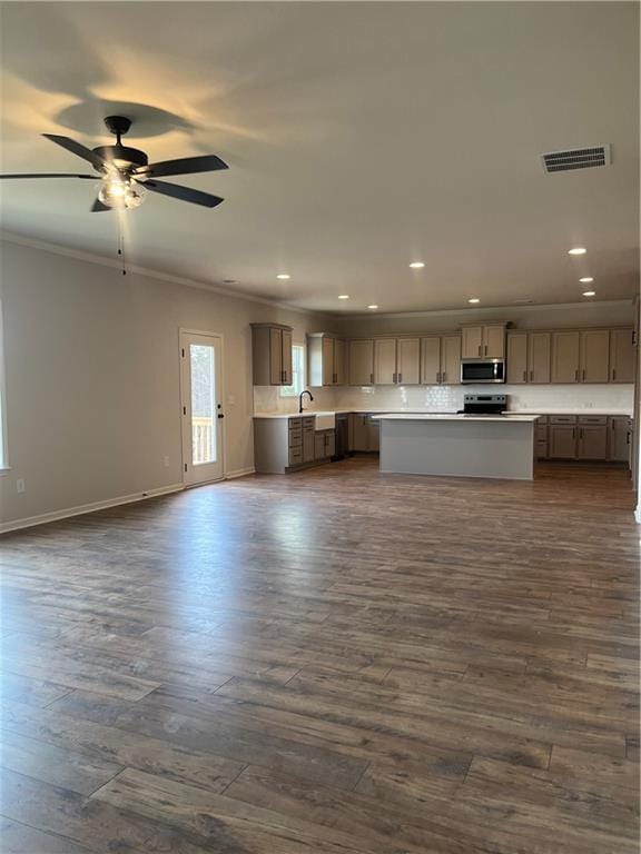 kitchen with stainless steel appliances, dark wood-type flooring, open floor plan, and crown molding