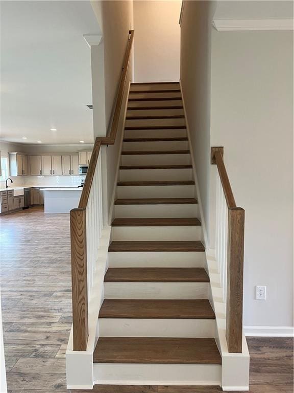 stairs featuring recessed lighting, baseboards, wood finished floors, and ornamental molding