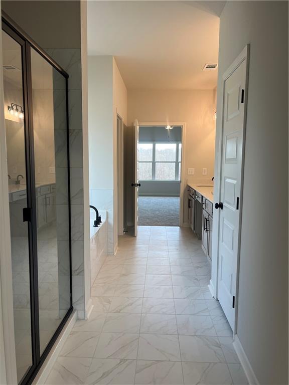 full bath with vanity, visible vents, a stall shower, a garden tub, and marble finish floor