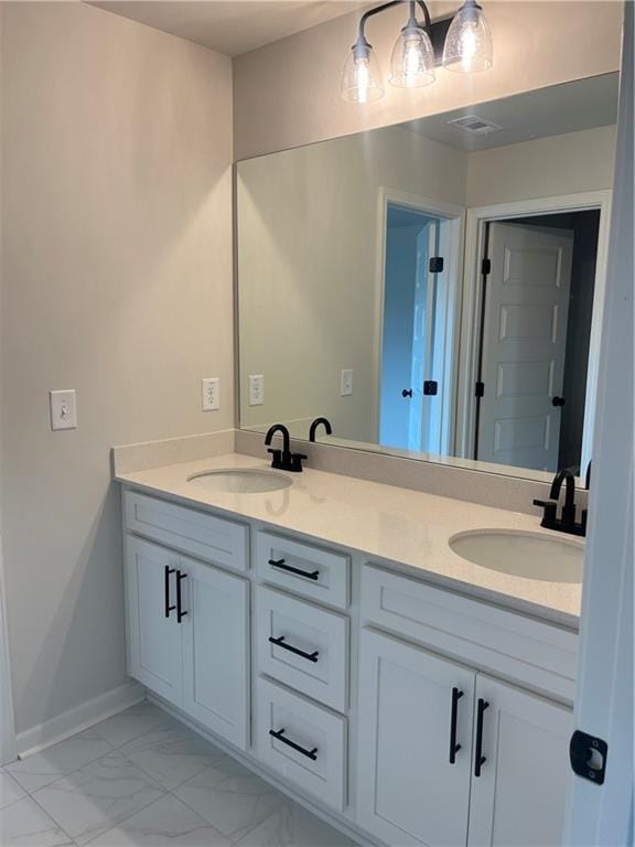 bathroom featuring a sink, marble finish floor, and double vanity