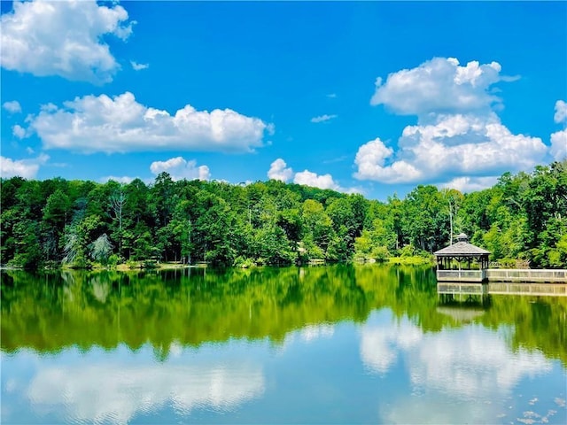 property view of water with a gazebo and a view of trees