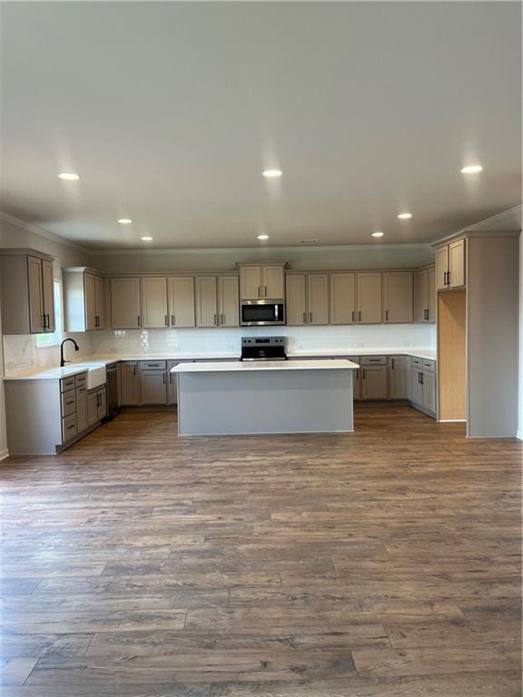 kitchen featuring backsplash, recessed lighting, appliances with stainless steel finishes, light countertops, and dark wood-style flooring