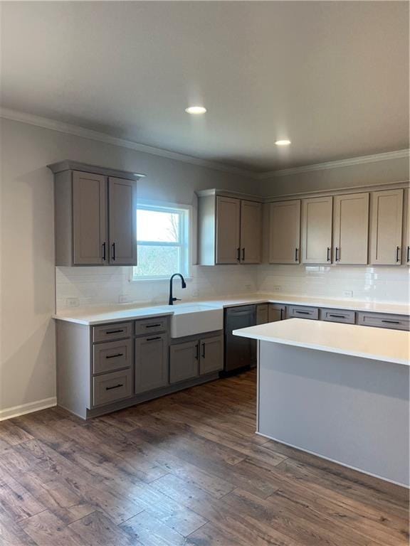 kitchen with a sink, dishwasher, dark wood-style flooring, and gray cabinetry