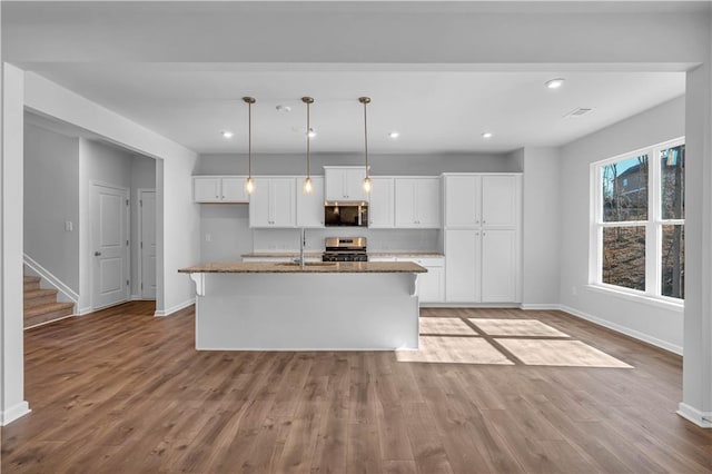 16 Grove Pointe Way SE, Cartersville, GA 30120 - kitchen with appliances with stainless steel finishes, baseboards, white cabinetry, a sink, and wood finished floors