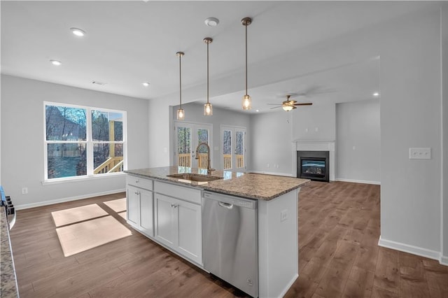 16 Grove Pointe Way SE, Cartersville, GA 30120 - kitchen featuring stainless steel dishwasher, a sink, a glass covered fireplace, white cabinetry, and decorative light fixtures