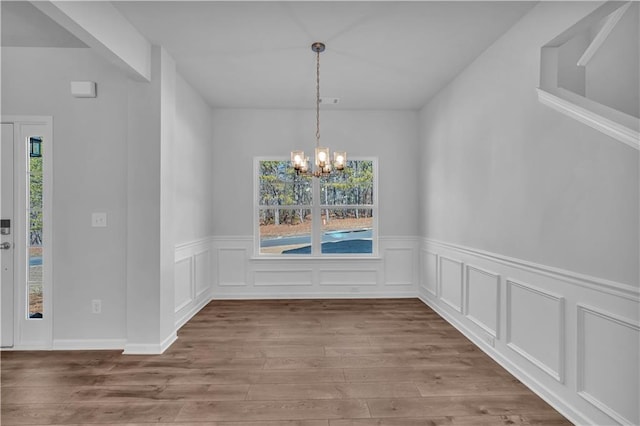 16 Grove Pointe Way SE, Cartersville, GA 30120 - unfurnished dining area featuring a chandelier, wood finished floors, a wainscoted wall, and a decorative wall