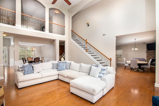 3631 Guinevere Trce, Douglasville, GA 30135 - living room with a chandelier, a towering ceiling, wood finished floors, ceiling fan, and ornate columns