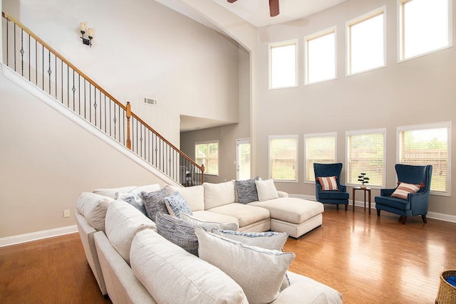 3631 Guinevere Trce, Douglasville, GA 30135 - living room featuring ceiling fan, wood finished floors, stairway, a high ceiling, and baseboards