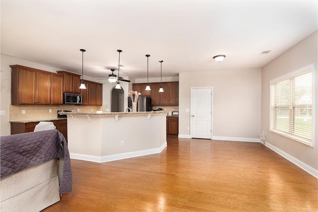 3631 Guinevere Trce, Douglasville, GA 30135 - kitchen featuring stainless steel appliances, open floor plan, light wood finished floors, and tasteful backsplash