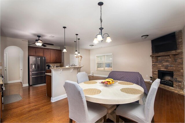 3631 Guinevere Trce, Douglasville, GA 30135 - dining area with a fireplace, arched walkways, dark wood-style flooring, and a ceiling fan