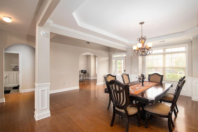 3631 Guinevere Trce, Douglasville, GA 30135 - dining space with arched walkways, a raised ceiling, dark wood-style floors, ornate columns, and a chandelier