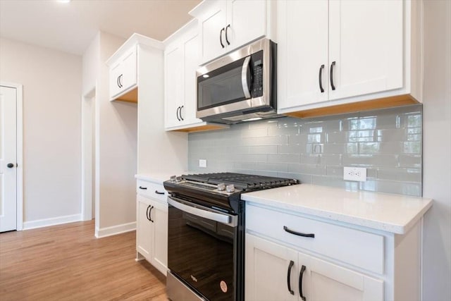 kitchen with light stone counters, decorative backsplash, white cabinets, and appliances with stainless steel finishes