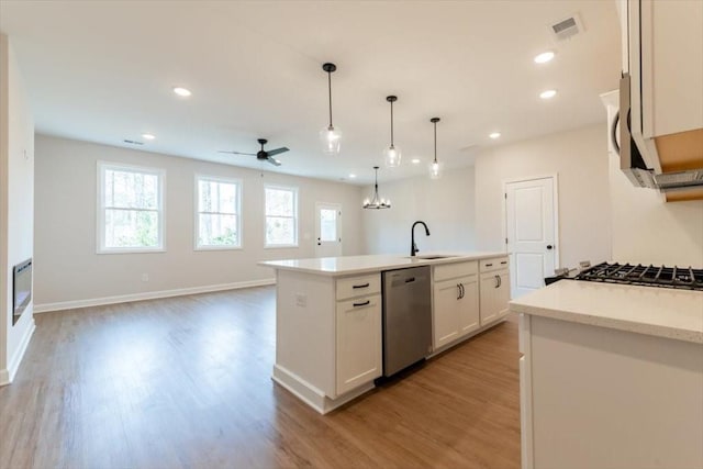 kitchen with pendant lighting, sink, a kitchen island with sink, white cabinets, and stainless steel dishwasher