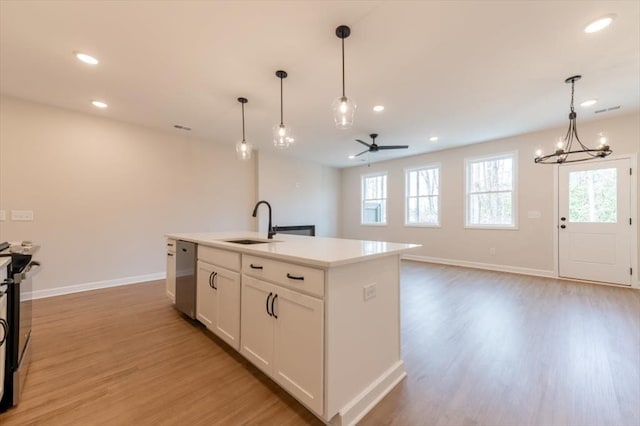 kitchen featuring pendant lighting, a kitchen island with sink, sink, and light hardwood / wood-style floors