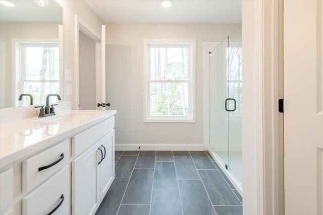 bathroom featuring a healthy amount of sunlight, a shower with shower door, and vanity