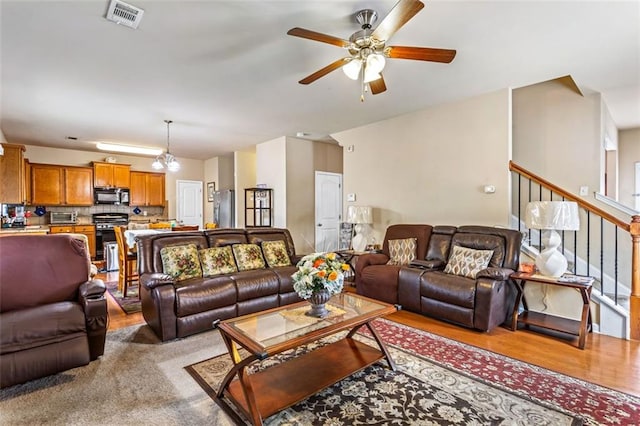 living room featuring visible vents, ceiling fan, wood finished floors, and a toaster