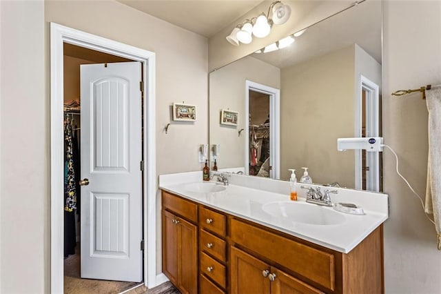bathroom featuring a sink, double vanity, and a spacious closet