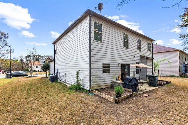 back of house featuring a lawn, cooling unit, and a patio area