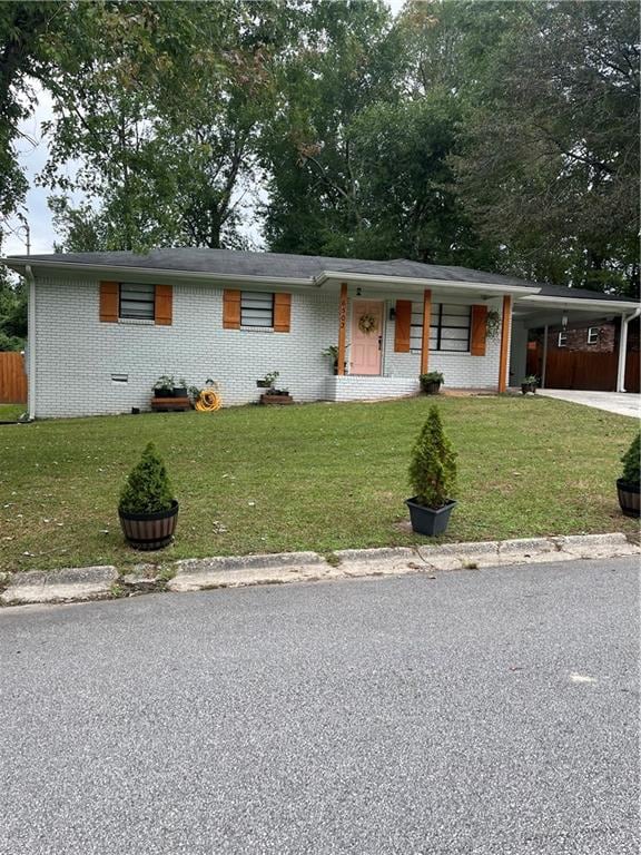 ranch-style home with a carport and a front yard