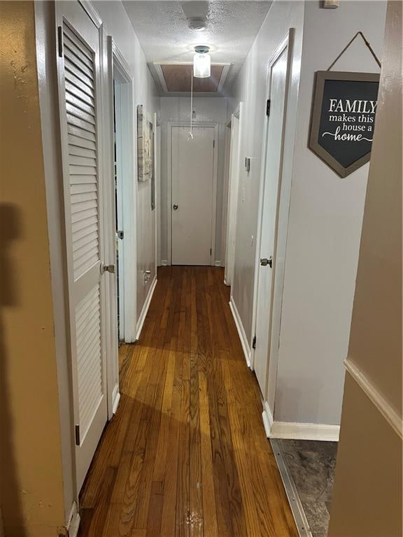 hallway with hardwood / wood-style flooring and a textured ceiling