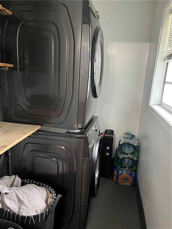 clothes washing area featuring stacked washer / drying machine