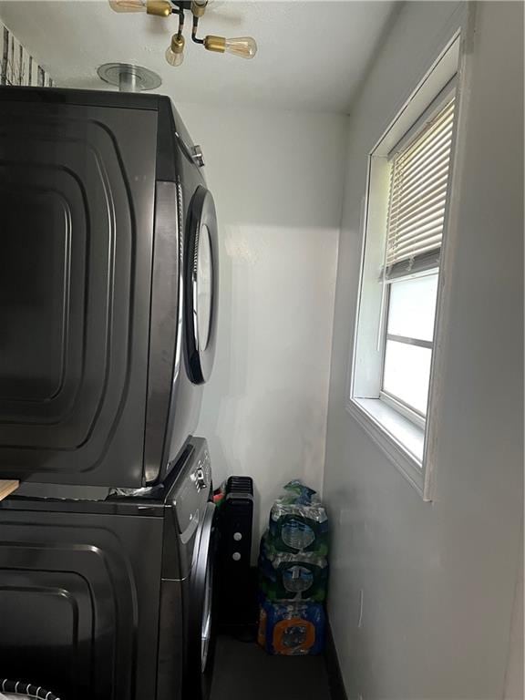 clothes washing area with stacked washer / dryer