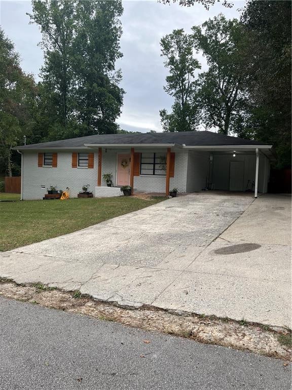 single story home with a front lawn and a carport