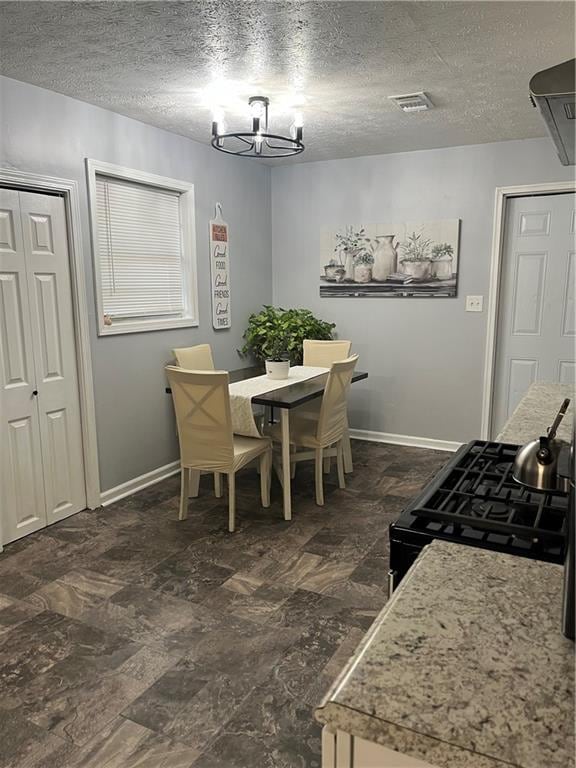 dining room featuring a textured ceiling and an inviting chandelier