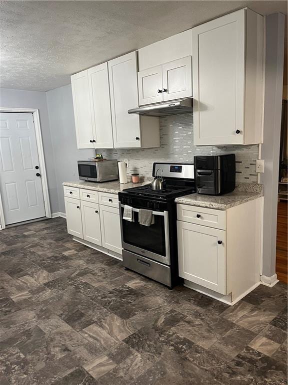 kitchen featuring a textured ceiling, stainless steel appliances, white cabinetry, and decorative backsplash