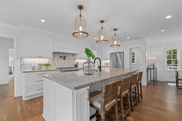 5143 Meadowlake Ln, Dunwoody, GA 30338 - kitchen with high end fridge, premium range hood, wood finished floors, recessed lighting, and tasteful backsplash