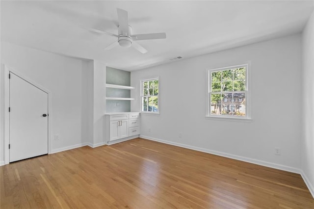 5143 Meadowlake Ln, Dunwoody, GA 30338 - empty room with light wood-type flooring, a ceiling fan, baseboards, and built in features