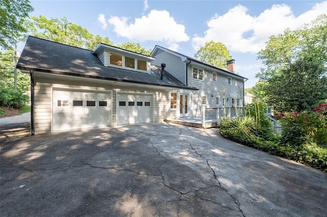 5143 Meadowlake Ln, Dunwoody, GA 30338 - view of front of house featuring driveway, a garage, a chimney, and a wooden deck