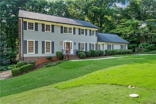 5143 Meadowlake Ln, Dunwoody, GA 30338 - colonial-style house featuring a front lawn and view of scattered trees
