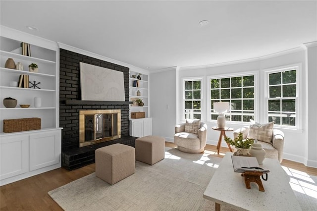 5143 Meadowlake Ln, Dunwoody, GA 30338 - living area featuring built in shelves, wood finished floors, a fireplace, baseboards, and crown molding