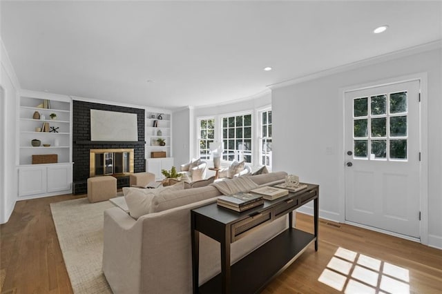 5143 Meadowlake Ln, Dunwoody, GA 30338 - living area with a brick fireplace, crown molding, wood finished floors, built in features, and recessed lighting