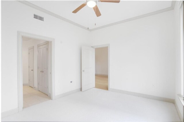 spare room featuring baseboards, ceiling fan, carpet, and crown molding