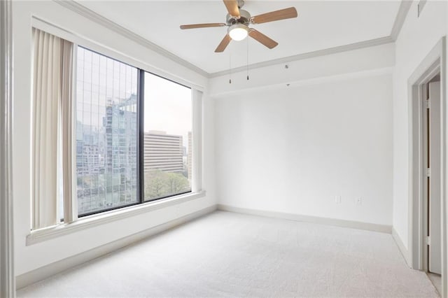 unfurnished room featuring light carpet, ceiling fan, ornamental molding, and baseboards