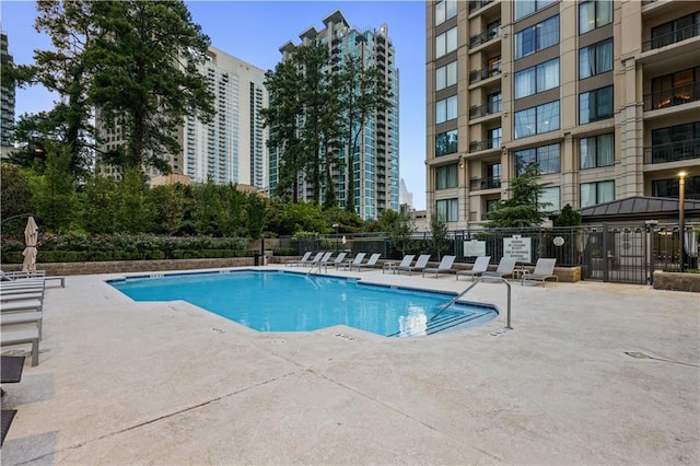 pool with fence and a patio