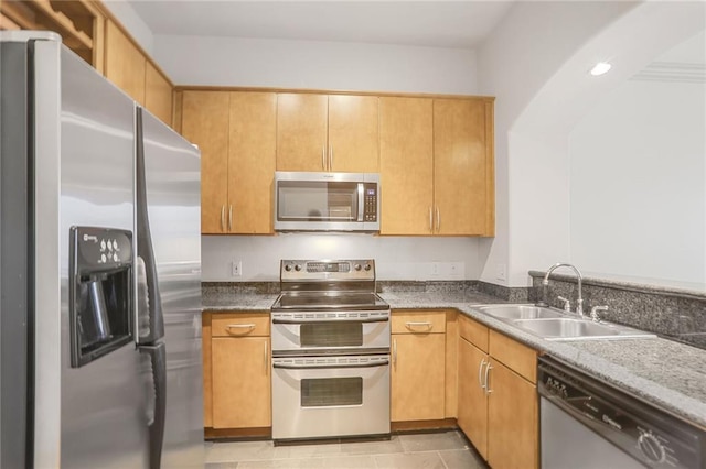 kitchen with light tile patterned floors, appliances with stainless steel finishes, and a sink