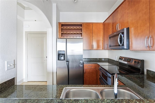 3445 Stratford Rd NE Unit 1605, Atlanta, GA 30326 - kitchen with stainless steel appliances, dark countertops, brown cabinetry, open shelves, and arched walkways